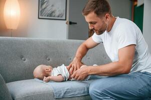 Changing diapers. Father with toddler is at home,, taking care of his son photo