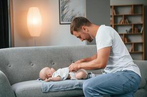 Changing ,diapers. Father with toddler is at home, taking care of his son photo
