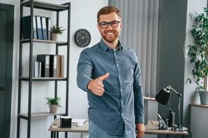 Giving hand. Man is working in the modern office. Conception of business and freelance photo