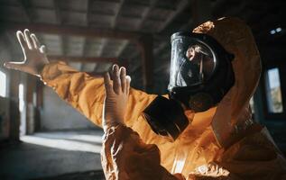 Light ,from nuclear explosion. Man dressed in chemical protection suit in the ruins of the post apocalyptic building photo