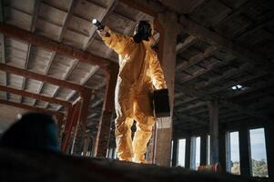 Using ,the flashlight. Man, dressed in chemical protection suit in the ruins of the post apocalyptic building photo