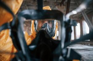 View ,through the respirator. Man dressed in chemical protection suit in the ruins of the post apocalyptic building photo