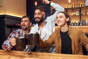 Soccer fans ,watching match. Three friends are in the bar drinking beer and having a good time photo