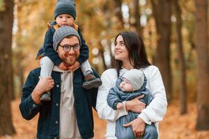 Father ,with his son on hands walking with mother that is with toddler photo