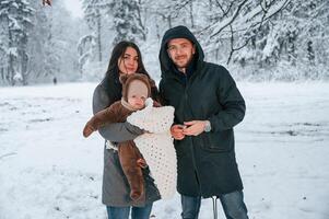 Parents with little son is ,in the winter park together photo