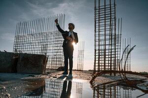 Beautiful, background ,with evening sunlight. Businessman in formal clothes is on the construction site photo