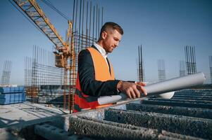 In ,orange colored uniform. Man is working on the construction site at daytime photo