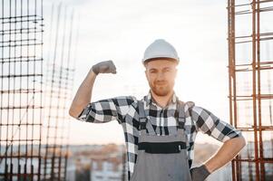 Showing ,biceps. Conception of succes. Man is working on the construction site at daytime photo