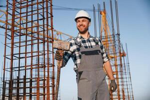 With big hammer in hands. ,Man is working on the construction site at daytime photo