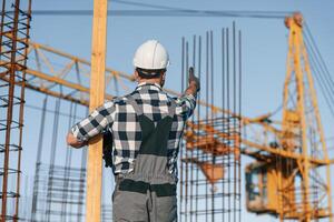 Giving ,orders to crane operator. Man is working on the construction site at daytime photo