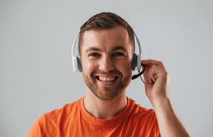 Conception, of call center. In headset. Handsome man is in the studio against white background photo