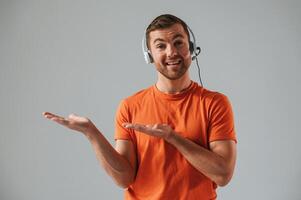 Conception ,,of call center. In headset. Handsome man is in the studio against white background photo