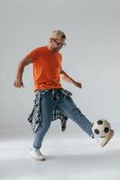 Doing, tricks, playing with soccer ball. Handsome man is in the studio against white background photo