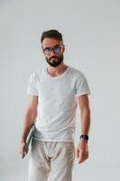Front view. Holding ,laptop. Handsome man is in the studio against white background photo