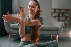 Warm up exercises. Young woman in yoga clothes ,doing fitness indoors photo