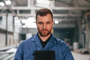 Portrait of factory ,worker that is in blue uniform indoors photo