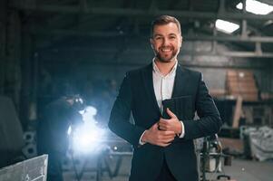 Manager in black formal wear at the factory. photo