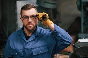Portrait ,of factory worker that is in blue uniform indoors photo