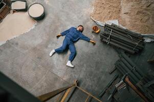 Top, view of dead factory worker that lying on the ground. Conception of safety, bad accident photo