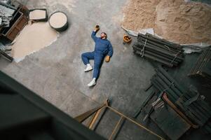 Top view ,of dead factory, worker that lying on the ground. Conception of safety, bad accident photo