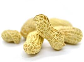 There is a sizable pile of peanuts still inside their shells, beautifully arranged on a white background for a clean and simple presentation photo