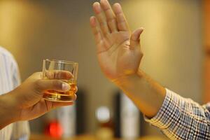 Man Refusing Alcoholic Drink Demonstrating Rejection and Responsible Decision Making photo