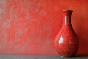 Red Ceramic Vase Against a Textured Red Wall photo