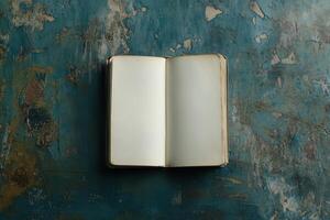 Open Blank Book on a Weathered Blue Surface photo
