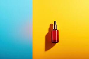 Red Glass Dropper Bottle on Yellow and Blue Background photo