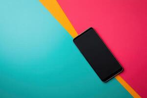Black Smartphone on a Teal, Yellow, and Pink Background photo