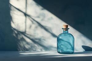 Blue Glass Bottle with Cork Stopper in Sunlit Room photo