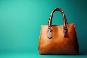 Brown leather handbag on teal background photo