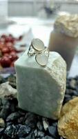 Luxurious silver ring decorated with moonstone on a natural jade base. photo