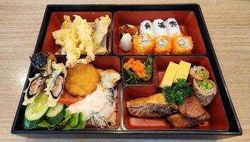Colorful Japanese Bento Box with Sushi, Tempura, and Fresh Vegetables photo