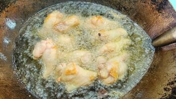 Sizzling Chicken Wings Frying in Hot Oil on a Wok photo