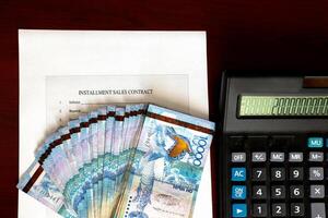 Paper Kazakh money and calculator on the table close-up. photo