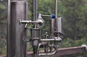 Stainless steel storage and processing tanks on a beautiful day. photo