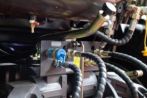 Hoses of modern hydraulic machine on a sunny day photo