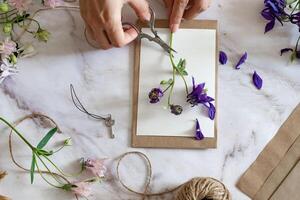 A rustic and elegant scene someone is making a bouquet of flowers, using brown paper, twine, and vintage scissors. photo