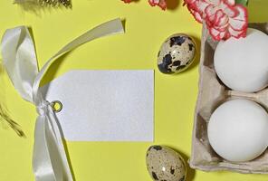 Happy Easter. Natural dyed colorful eggs in paper tray with linen napkin and spring flowers in rustic room. Countryside still life photo