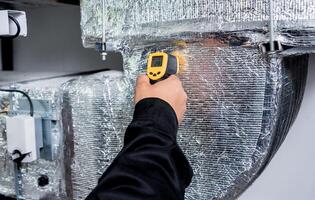 Technician use infrared thermal imaging camera to check temperature at fuse-box photo