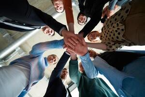 A group of business professionals, captured from a low angle, holding hands to symbolize unity and teamwork. photo