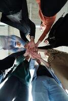 A group of business professionals, captured from a low angle, holding hands to symbolize unity and teamwork. photo