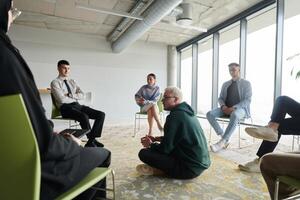 Corporate business team meeting with a manager or coach. Group of happy diverse, multiracial people sitting in a circle photo
