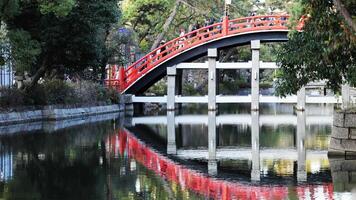 Red bridge Sorihashi reflected beautifully on calm waters at Sumiyoshi Taisha Shrine in Osaka Japan. Red bridge Sorihashi or Sumiyoshi Taisha red bridge in New year which crowd people for make wish video