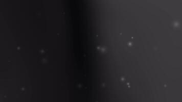 Glowing particles float on black gray background video