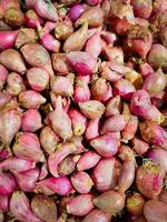 Many red onions create a vibrant and textured backdrop, ideal for food photography, culinary projects, or agriculture related designs photo