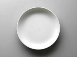 Ai. A pristine white ceramic plate rests on a sleek gray surface, embodying minimalist elegance and modern dining sophistication photo