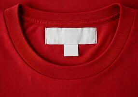 A red t - shirt with a white label on the back photo
