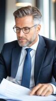 Businessman in a classic suit signs a contract in the office. Confident look, serious expression. Concept of business, leadership, success and professionalism. photo